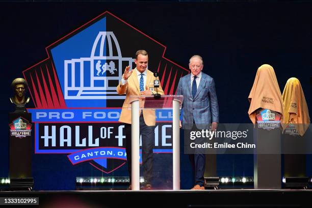 Peyton Manning greets the crowd with his father Archie Manning during the NFL Hall of Fame Enshrinement Ceremony at Tom Benson Hall Of Fame Stadium...