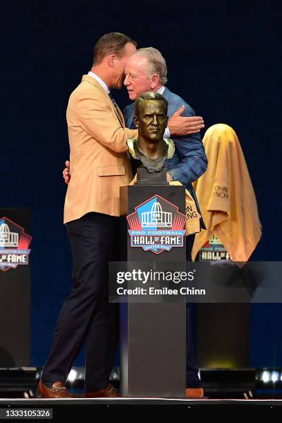 Peyton Manning shares a moment with his father Archie Manning after unveiling his bust during the NFL Hall of Fame Enshrinement Ceremony at Tom...