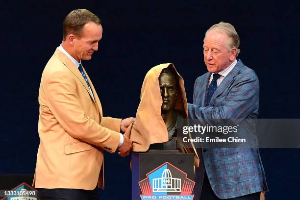 Peyton Manning unveils his bust with his father Archie Manning during the NFL Hall of Fame Enshrinement Ceremony at Tom Benson Hall Of Fame Stadium...