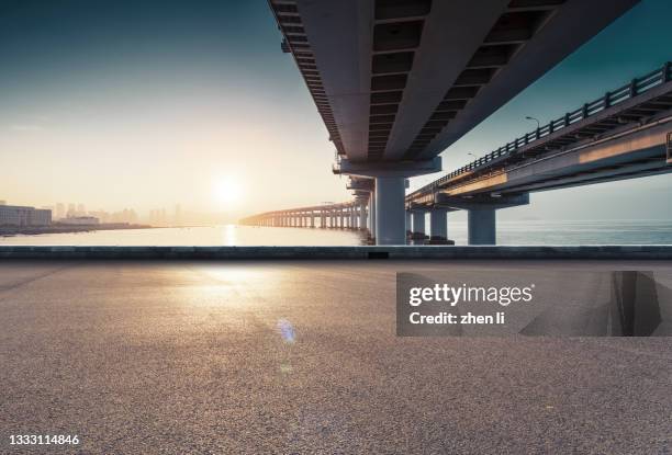 asphalt road under the viaduct - building bottom view stock pictures, royalty-free photos & images