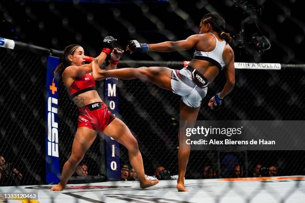 Tecia Torres ducks the kick of Angela Hill during their Strawweight fight at Toyota Center on July 7, 2021 in Houston, Texas.