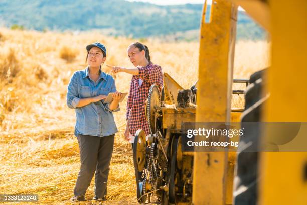 two multi-ethnic female farmers using digital tablet in farm field - young agronomist stock pictures, royalty-free photos & images