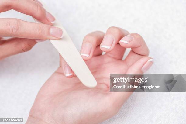 woman hands in a nail salon receiving a manicure. - fingernail foto e immagini stock