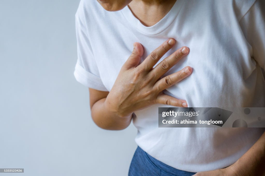 Woman hand holding chest with symptom heart attack disease.
