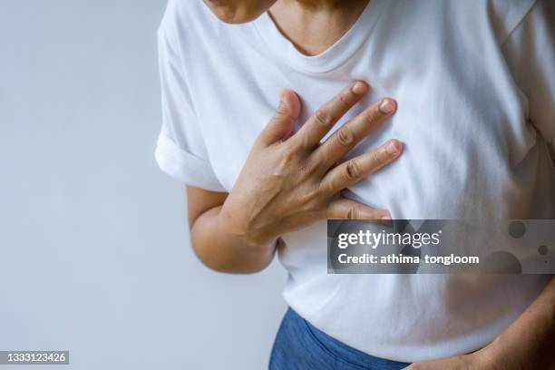 woman hand  holding chest with symptom heart attack disease. - female torso stock pictures, royalty-free photos & images