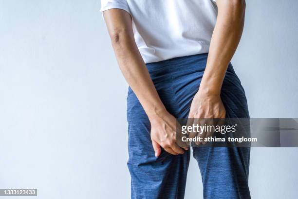 woman with hemorrhoids ,holding her butt in pain. - woman hemorrhoids stock pictures, royalty-free photos & images