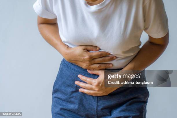 woman having painful stomachache. - stomach stock pictures, royalty-free photos & images