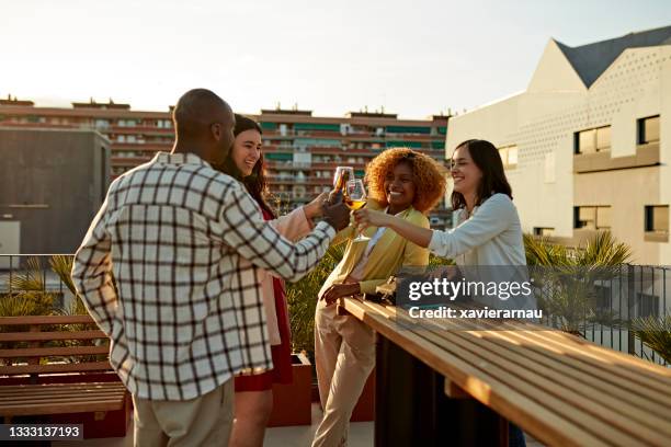 multiethnische gruppe, die getränke auf der dachterrasse genießt - feierabend stock-fotos und bilder