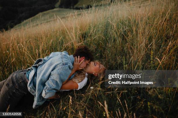 portrait of young couple on a walk outdoors in nature, kissing. - young couple enjoying a walk through grassland stock pictures, royalty-free photos & images