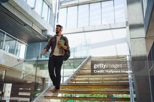 young university student with headphones indoors at school. - campus imagens e fotografias de stock