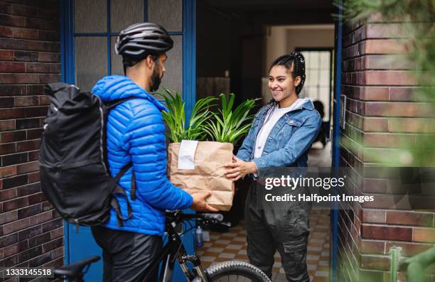 delivery man with bicycle delivering potted plants outdoors in city, coronavirus concept. - covid 19 food stock pictures, royalty-free photos & images