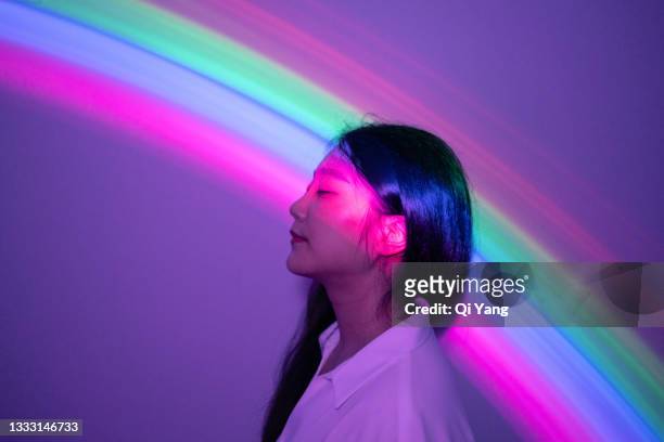young asian woman on rainbow background - viola colore foto e immagini stock