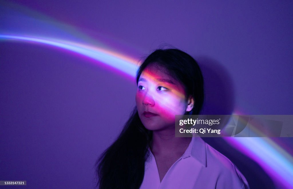 Portrait of young Asian woman on rainbow background