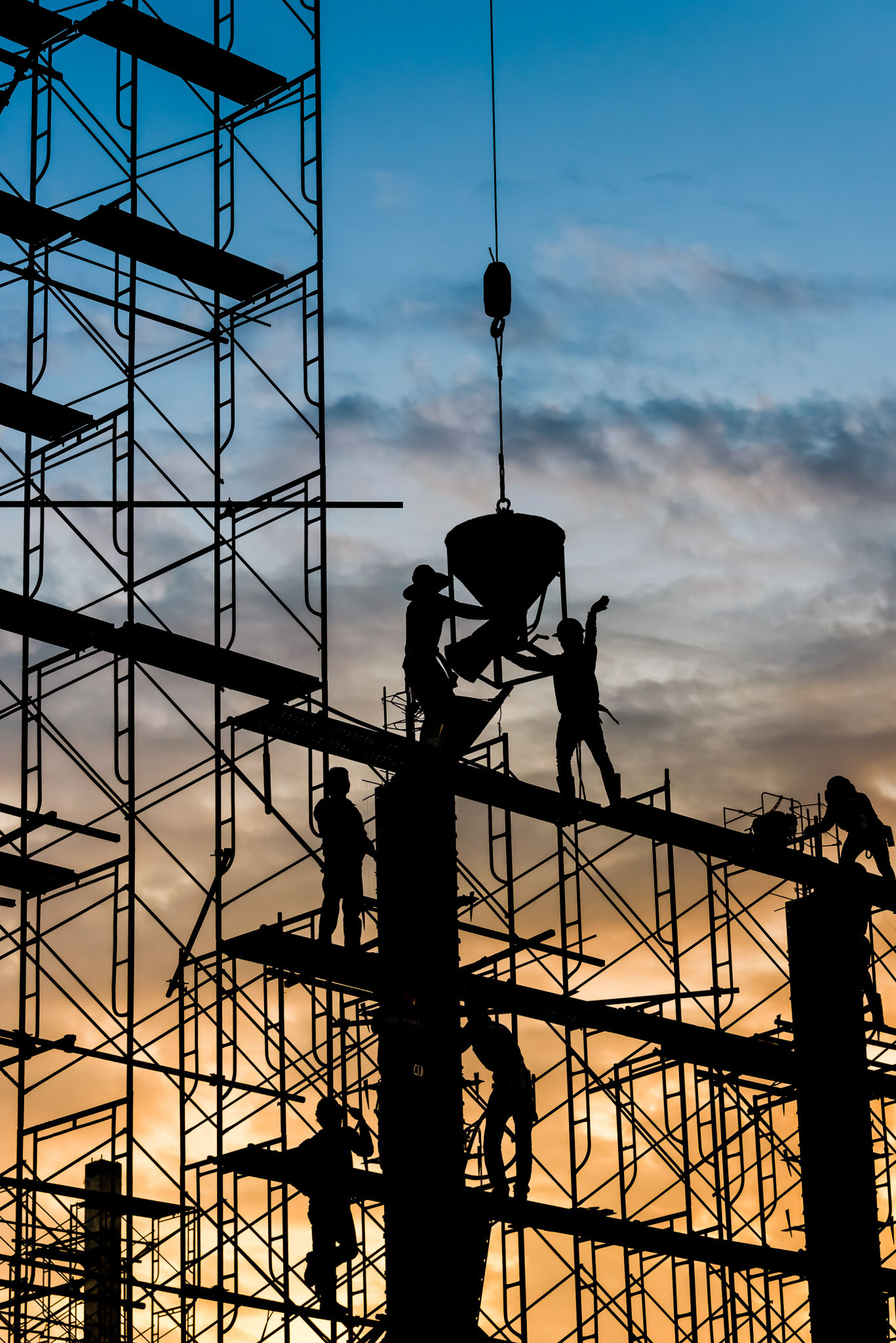 Silhouette of worker. Construction Building casting concrete work on scaffolding Silhouette of worker. Construction Building casting concrete work on scaffolding