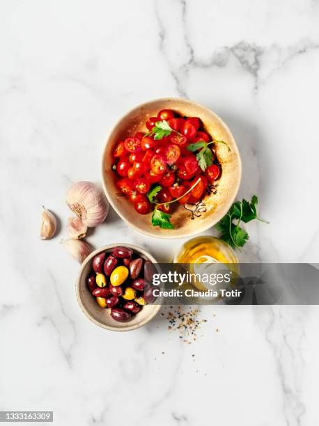 food ingredients ( tomatoes, olives, garlic, and olive oil) on white background - chopped tomatoes foto e immagini stock