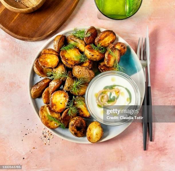 roasted potatoes and a bowl of dipping sauce on pink background - roast potatoes stock pictures, royalty-free photos & images