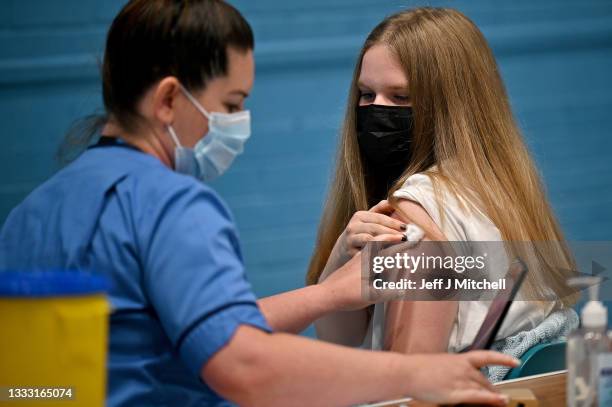 Teenager Eve Thomson receives a covid vaccination as Scotland's First Minister Nicola Sturgeon visits a vaccination centre on August 9 in Barrhead,...