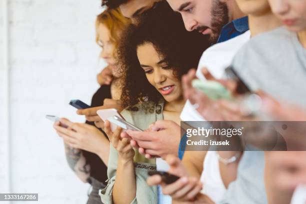 group of students using mobile phones - medium group of people stock pictures, royalty-free photos & images