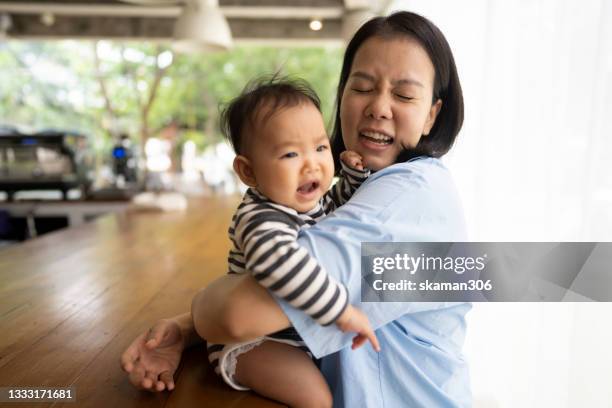 asian female daughter feeling negative emotion and  crying and shouting  with her mother embracing - compassionate eye foto e immagini stock