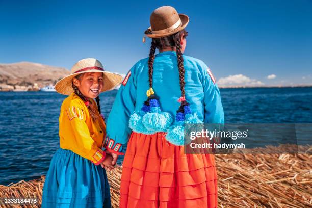 mother and her daughter looking at view on uros floating island, lake tititcaca, peru - floating island stock pictures, royalty-free photos & images