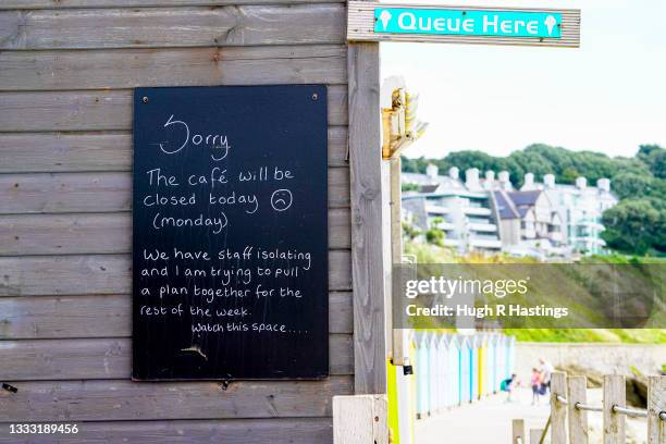 Signage outside the Castle Beach Cafe advises customers of the need to close due to Covid-19 isolation rules affecting staff on August 09, 2021 in...