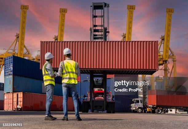 engineers are overseeing the transportation of cargo with containers inside the warehouse. container in export and import business and logistics. - warehouse loading stock pictures, royalty-free photos & images