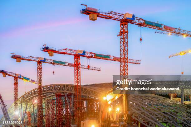 silhouettes of tower cranes against the evening sky. - cable winch stock pictures, royalty-free photos & images