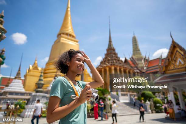 young woman traveler with backpack traveling into beautiful pagoda in wat pra kaew - phuket stock pictures, royalty-free photos & images