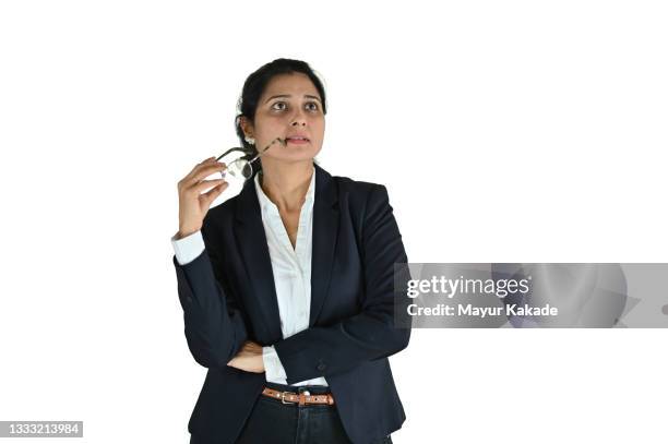 portrait of a mid adult woman holding eye glasses in one hand and thinking against white background - indian corporate women background stockfoto's en -beelden