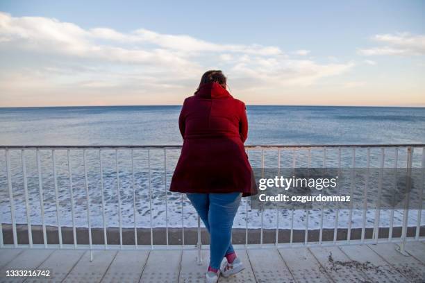 young overweight woman standing alone on the beach - plus size fashion model stock pictures, royalty-free photos & images