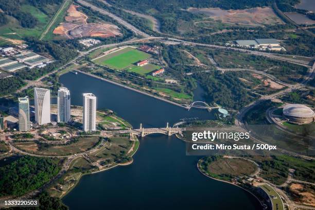 aerial view of river and buildings in city,putrajaya,malaysia - putrajaya stockfoto's en -beelden