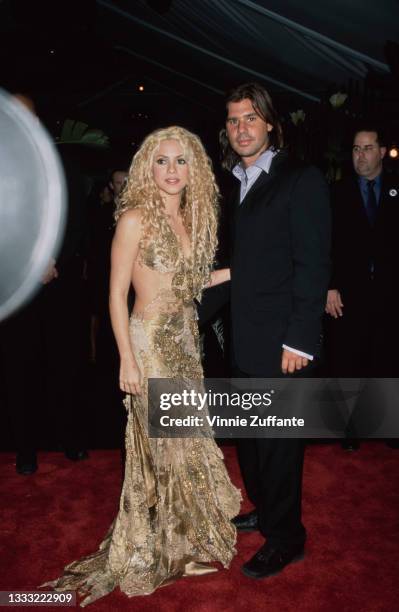 Colombian singer and songwriter Shakira, wearing a gold evening gown, and her partner, Argentine lawyer Antonio de la Rua attend the 43rd Annual...