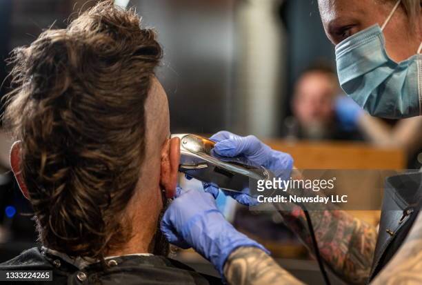 Hairdresser Tera Degregoris working on a Faux Hawk on Jesse Roberts at Noble Savage Barber Shop in Bay Shore, New York on July 10, 2021. The cut is a...