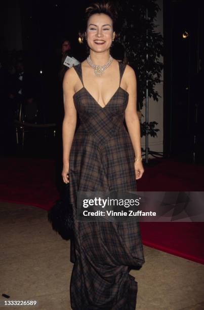 American-Canadian actress Jennifer Tilly, wearing a brown plaid full-length dress with a Queen Anne neckline, attends the 52nd Annual Golden Globe...