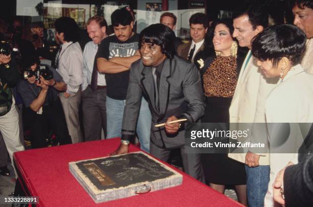American singer, songwriter and musician James Brown creating his handprints during his ceremony at Hollywood's RockWalk on Vine Street in Los...