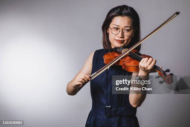 portrait of asian woman playing violin - classical musician stock pictures, royalty-free photos & images