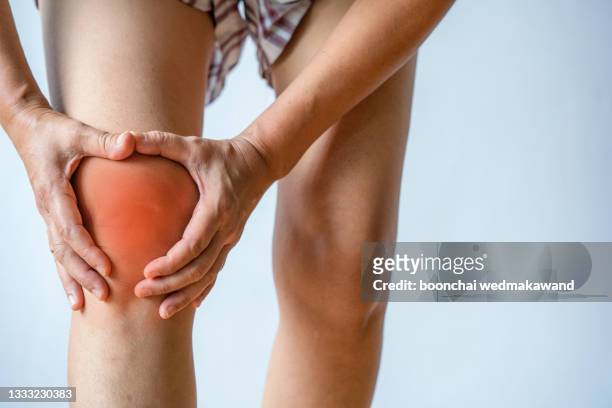 woman holding her painful knee on white background - inflammation stock pictures, royalty-free photos & images