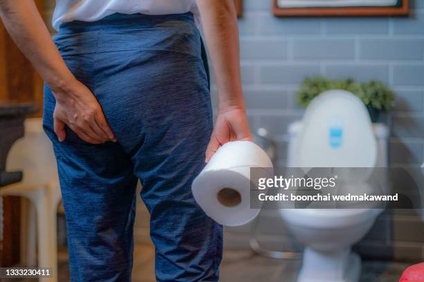 woman using toilet and suffers from diarrhea and hemorrhoids after wake up at home in the morning - woman hemorrhoids stock pictures, royalty-free photos & images