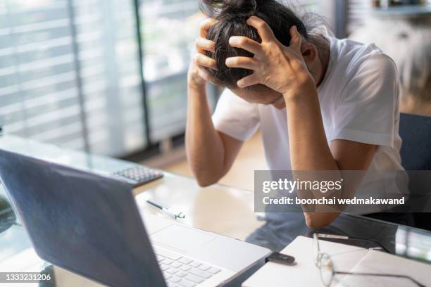 tired young business woman or student with a headache using laptop at the home office. - tesa foto e immagini stock