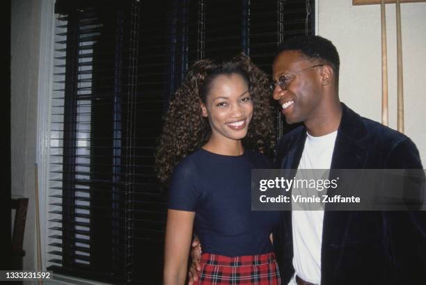 Haitian-born American actress and fashion model Garcelle Beauvais, wearing a tartan miniskirt and a navy blue t-shirt, and her husband, producer...