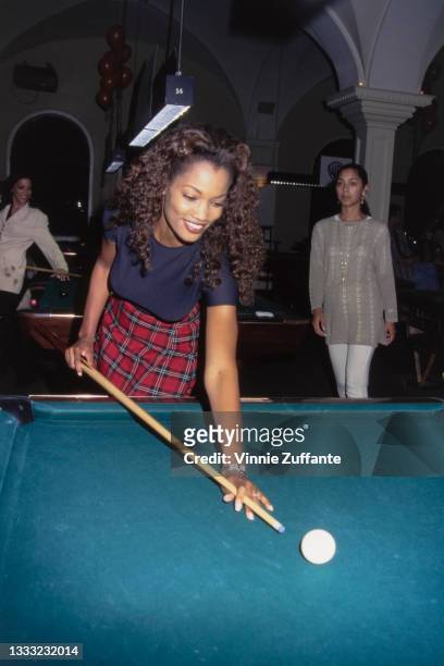 Haitian-born American actress and fashion model Garcelle Beauvais, wearing a tartan miniskirt and a navy blue t-shirt, attends a celebrity billiards...