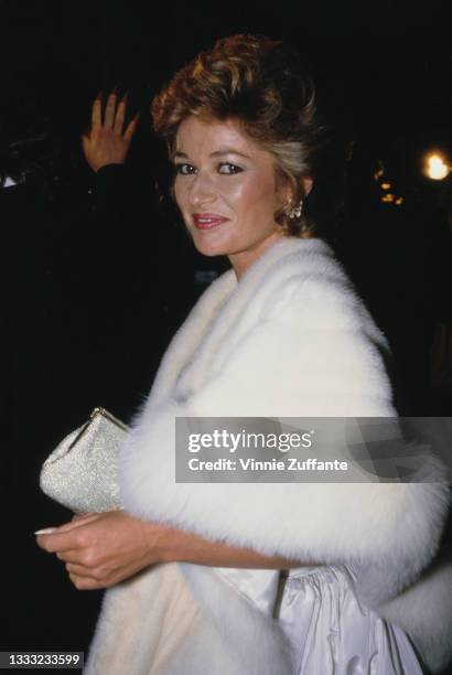 British actress Stephanie Beacham, wearing a white evening gown with a white fur wrap, attends the 44th Annual Golden Globe Awards, held at the...