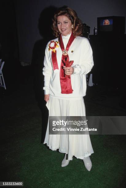 British actress Stephanie Beacham, wearing a white outfit with a red sash, attend the 62nd Annual Hollywood Christmas Parade at KTLA Studios in Los...