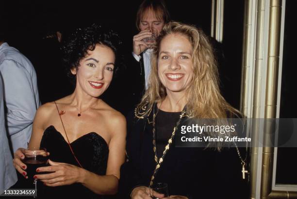 American singer, songwriter and guitarist Jane Wiedlin, wearing a black off-shoulder outfit, and American guitarist Charlotte Caffey, wearing a black...