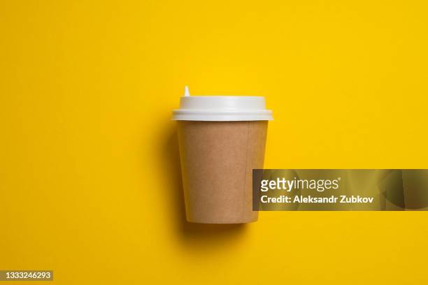 a disposable paper cup with a lid for coffee and tea on a bright pastel yellow background. coffee break. the concept of environmental protection. copy the space. - disposable cup bildbanksfoton och bilder