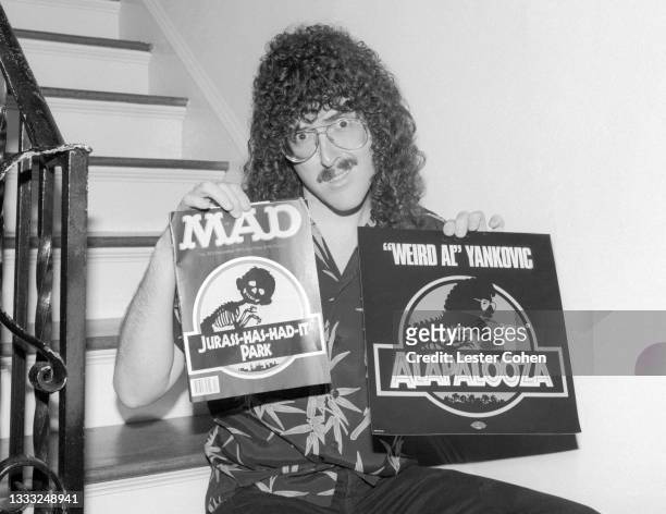 American singer, musician, record producer, and actor "Weird Al" Yankovic poses for a portrait with a MAD magazine and his LP "Alapalooza" circa...