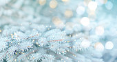 Long banner of white snowy Christmas tree background outdoor, lights bokeh around, and snow falling, Christmas atmosphere