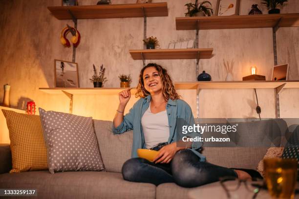 woman watching movie and eating potato chips - late night television bildbanksfoton och bilder
