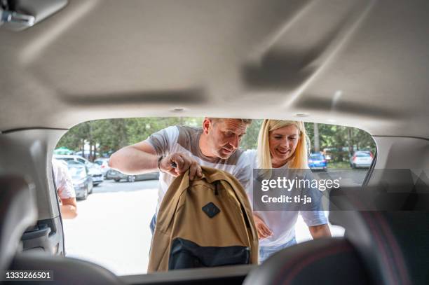 couple at the car trunk packing a backpack - boots stock pictures, royalty-free photos & images