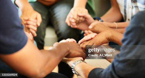 menschen, die während eines selbsthilfegruppentreffens händchen halten - group therapy stock-fotos und bilder